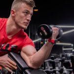 a man in a gym holding a dumbbell